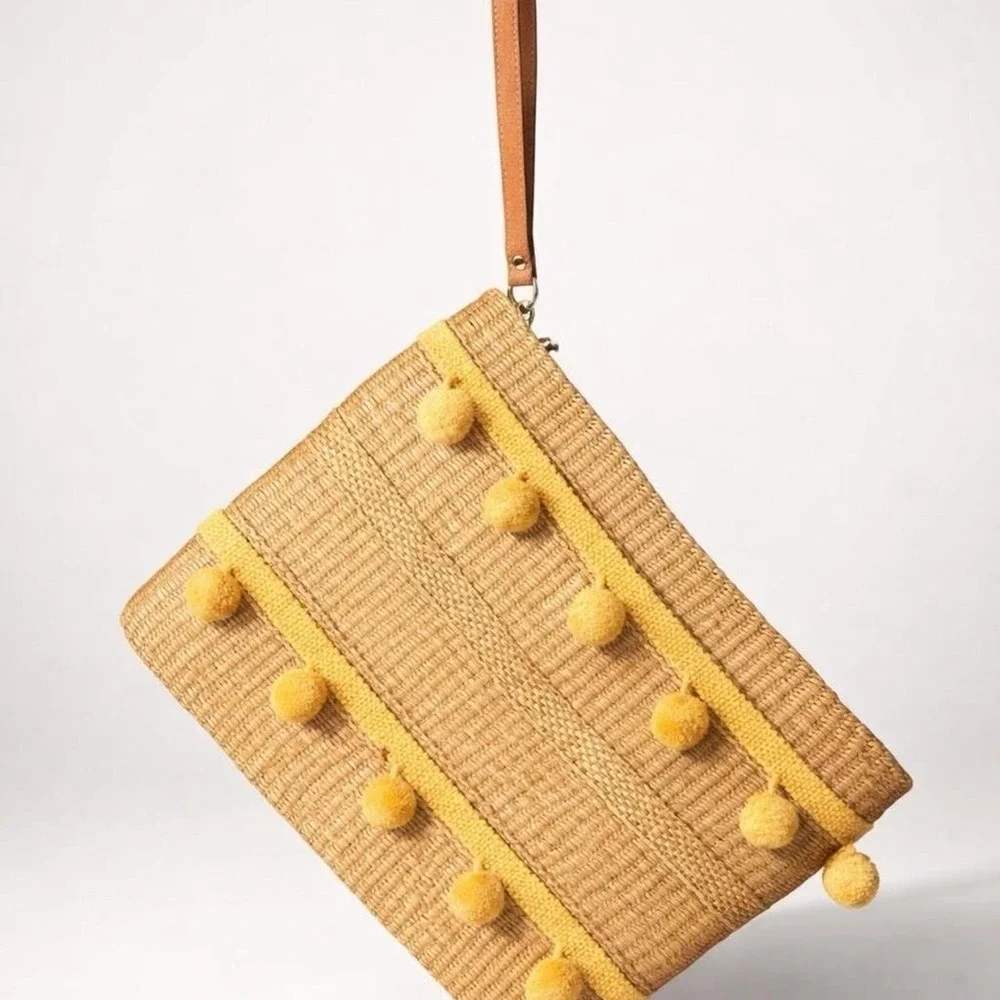 Yellow pom pom raffia clutch bag